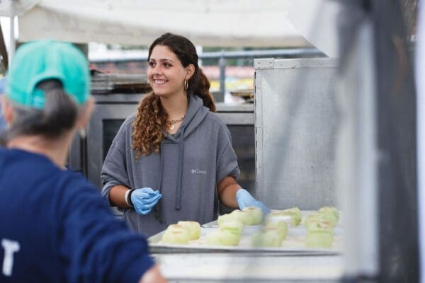 a woman with a tray of peeled apples