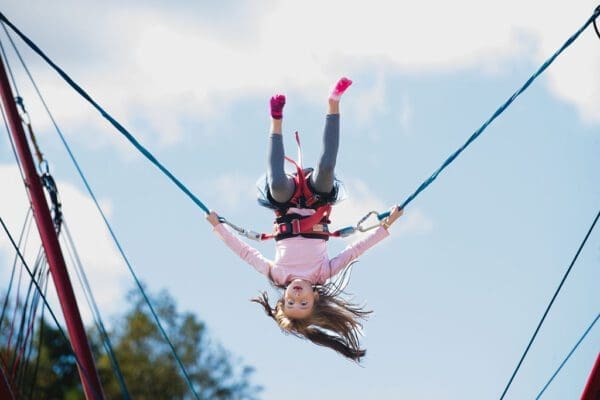 a girl doing flips on bungie cords