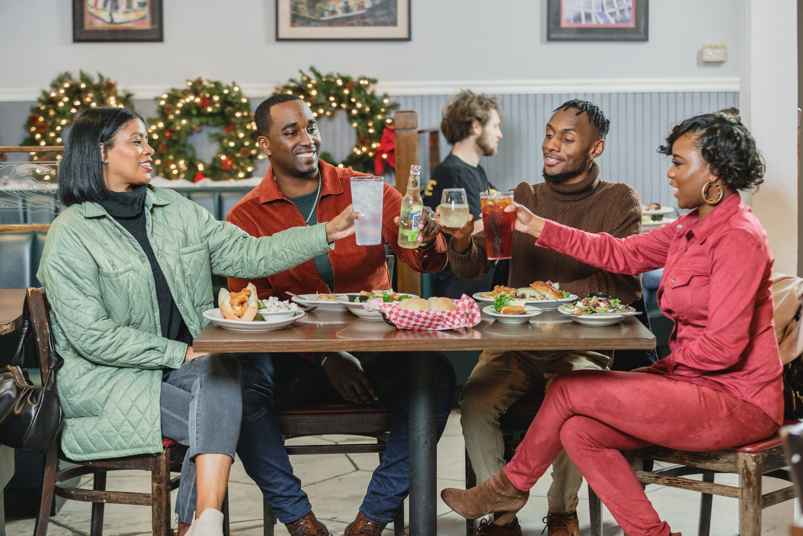 Two couples toast drinks over dinner at Cajun Depot Grill